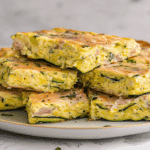 Dovlecei pane la cuptor cu ou – Uimitor de buni și ușor de făcut 6 Porții de dovlecei pane la cuptor cu ou stivuite pe o farfurie.