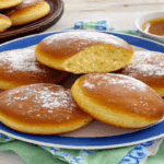 Secrete pentru gogoși pufoase într-o porție servită, cu o gogoașă secționată în centru.