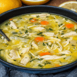 Ciorbă de pui a la grec văzută de sus, cu carne fragedă, legume și felii de lămâie