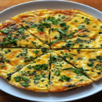 Frittata la air fryer tăiată felii, vedere de sus, cu ierburi proaspete și crustă aurie